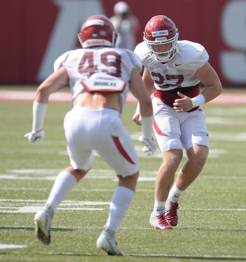 NWA Democrat-Gazette/Andy Shupe DEFENSIVE DRILLS: Arkansas linebackers Hayden Henry (right) and McKinley Williams run through a drill Tuesday during practice at the university practice facility in Fayetteville. The Razorbacks held a closed scrimmage Saturday.