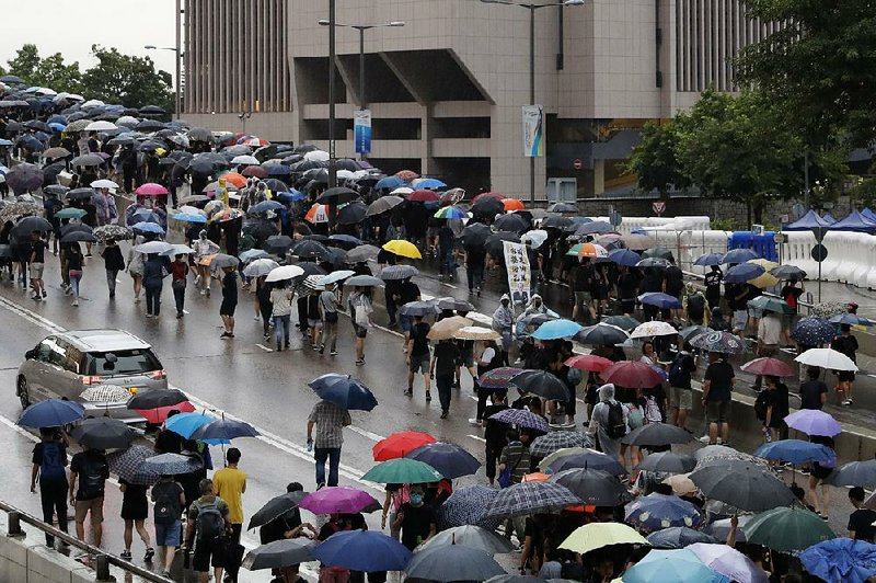 Pro-democracy protesters fill a major road in Hong Kong on Sunday as they march in the rain. More photos are available at arkansasonline.com/819hongkong/. 