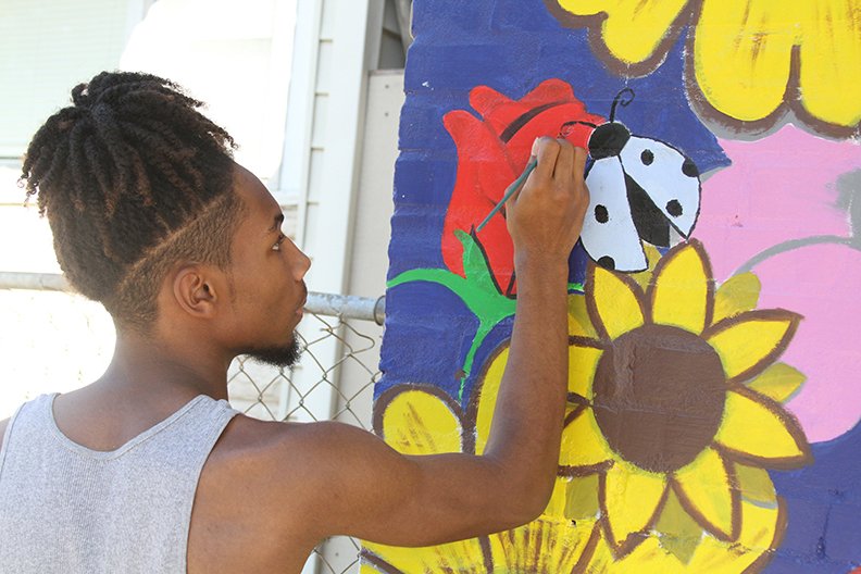The Sentinel-Record/Tanner Newton Ja'Leayiah Easter paints a flower while James Avery paints a ladybug on a new mural the two are working on with Anthony Tidwell at the Cutwell 4 Kids studio at 247 Silver St. Both have been students under Tidwell in his C4K program, and all three learned the art of painting murals from Italian artist Pepe Gaka.