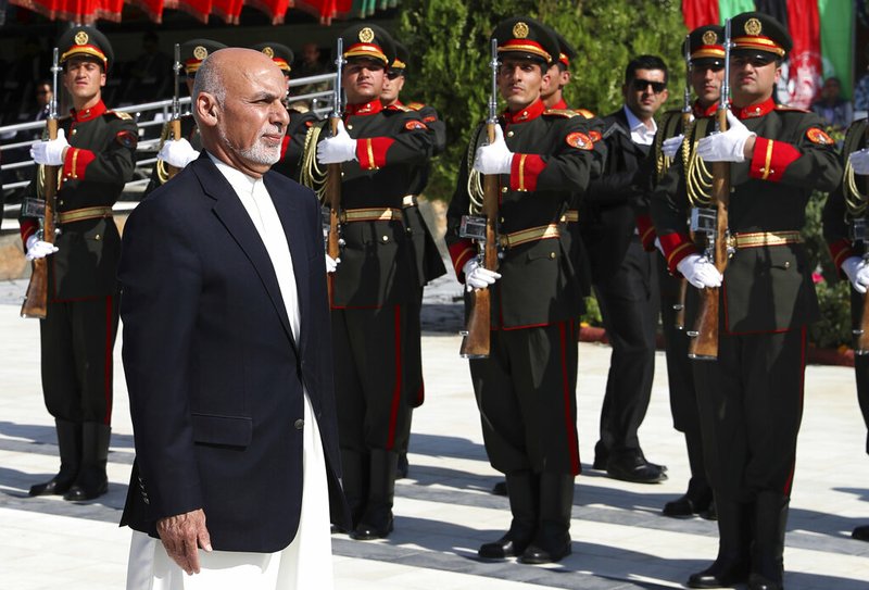 In this photo released by the Afghan Presidential Palace, Afghan President Ashraf Ghani inspects the honor guard during Independence Day celebrations at Defense Ministry in Kabul, Afghanistan, Monday, Aug. 19, 2019. Afghanistan's president is vowing to eliminate all safe havens of the Islamic State group as the country marks a subdued 100th Independence Day after a horrific wedding attack claimed by the local IS affiliate.(Afghan Presidential Palace via AP)
