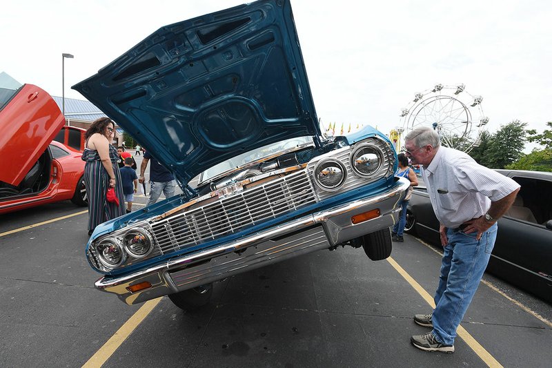 Dearl Masterson of Springdale checks out a 1964 Impala low rider Sunday at St. Raphael Catholic Church's annual Summerfest Family Fun Day in Springdale. The event featured food, a car show, police and fire vehicles, helicopter rides, music, games and a cake walk. NWA Democrat-Gazette/J.T. WAMPLER