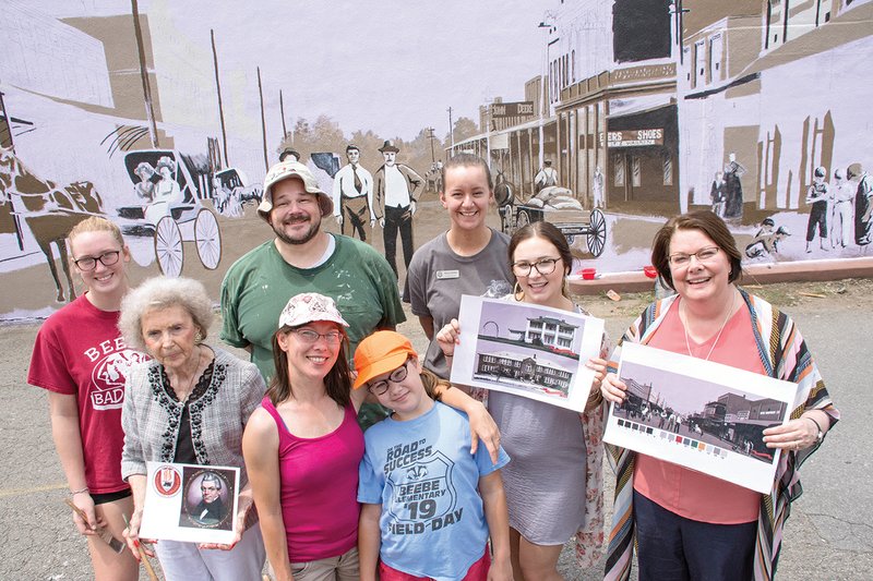 Thomas Fernandez and his team stand in front of the mural at 114 N. Main St. that commemorates the history of Beebe.  In the front row, from left, are Melba Brackin; Irina Fernandez; Anya Fernandez, 9; Ashton Warner, admissions representative for Arkansas State University-Beebe; and Jennifer Methvin, ASUB chancellor; and back row, Kyllee Jones, 16; Thomas Fernandez; and Stacey Dicken, an ASUB student recruiter. 