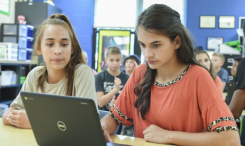 The Sentinel-Record/Grace Brown COMPUTER TIME: Lakeside seventh-graders Brenna Townley, left, and Alyssa Nugent log on to the game-based learning platform, "Kahoot!" on Monday. This was Lakeside School District's first day back in class.