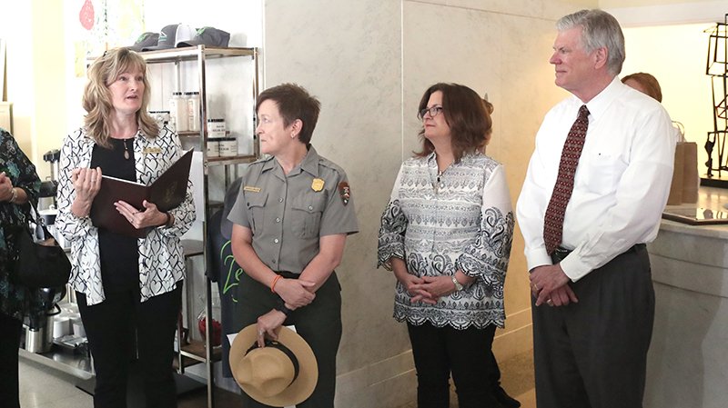 The Sentinel-Record/Richard Rasmussen GRAND OPENING: From left, Tracy Simmons, chief of Commercial Services and Leasing for the Midwest Region of the National Park Service in Ohama, Neb., addresses the crowd at Tuesday’s grand opening of the Hotel Hale, as Hot Springs National Park Superintendent Laura Miller and the bath house lessees, Ellen and Pat McCabe, listen.