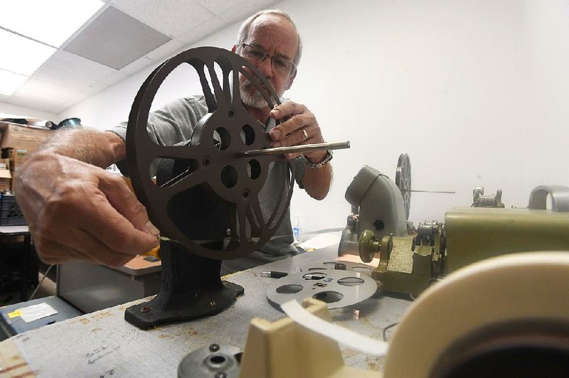 Randall Dixon, director of news archives and media at the David and Barbara Pryor Center for Arkansas Oral and Visual History, loads a film reel on an old editing table Tuesday in Fayetteville. 