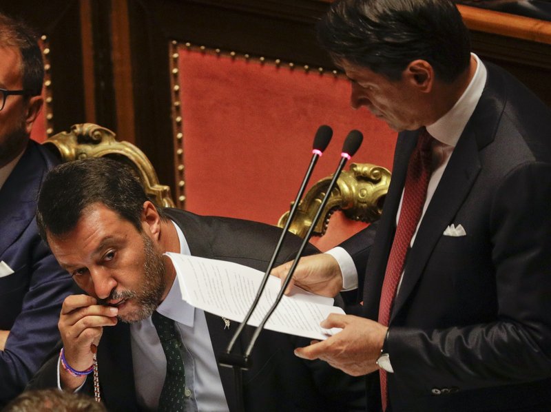 Italian Premier Giuseppe Conte addresses the Senate as Deputy-Premier Matteo Salvini kisses a rosary while sitting beside him, in Rome, Tuesday, Aug. 20, 2019. Italian Premier Conte blasted the League's leader Salvini for his decision to spark a government crisis that risks triggering "a spiral of political and financial instability." (AP Photo/Gregorio Borgia)