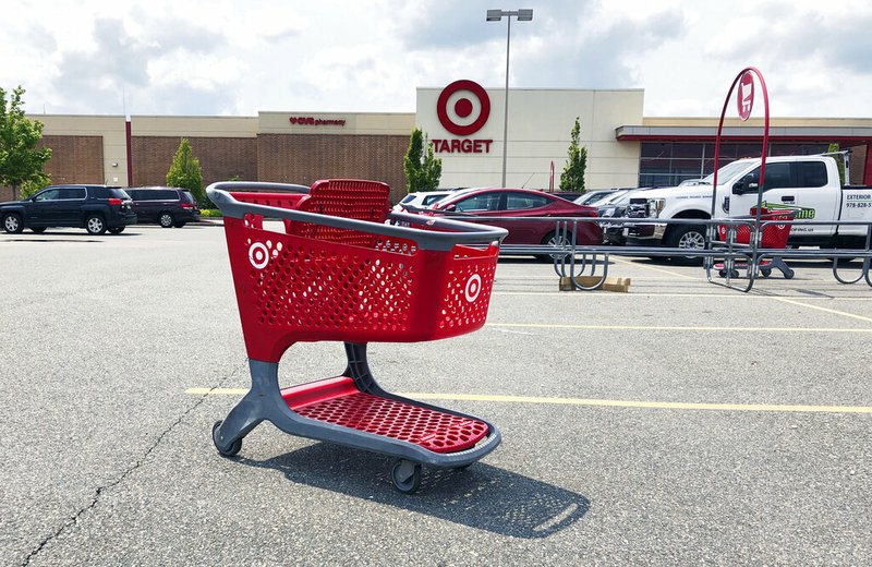 In this June 3, 2019, file photo a shopping cart sits in the parking lot of a Target store in Marlborough, Mass. Target Corp. reports financial results Wednesday, Aug. 21. (AP Photo/Bill Sikes, File)