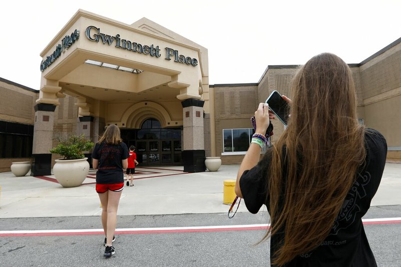 In this Tuesday, July 23, 2019 photo, Brinley Rawson, a 17-year-old Stranger Things fan from Gwinnett County, snaps a photo of Gwinnett Place Mall in Duluth, Ga. Stranger Things filmed much of season three at the mall, which was called Starcourt Mall in the show. (AP Photo/Andrea Smith)