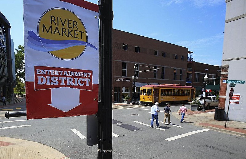  Arkansas Democrat-Gazette/STATON BREIDENTHAL --8/21/19--  Banners for the new River Market Entertainment District hang in the area Wednesday as pedestrians walk through the area during the lunch hour. The new entertainment district will allow open containers of alcohol to be carried outdoors in the specified area of downtown Little Rock. 