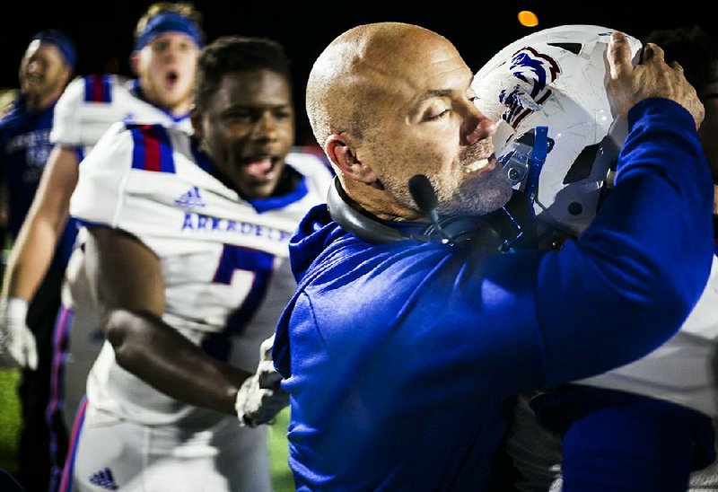 Coach J.R. Eldridge celebrates with his team after Arkadelphia defeated Shiloh Christian 30-17 in the Class 4A semifinals in Springdale. The Badgers went on to shut out Joe T. Robinson for the state championship.  