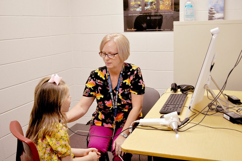 RACHEL DICKERSON/MCDONALD COUNTY PRESS Nurse Melinda Taylor (right) uses a specialized instrument to measure Payton Eckman's heartbeat during a telemedicine demonstration at Rocky Comfort School on Wednesday, Aug. 14.