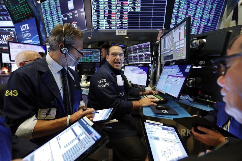 Specialist Anthony Matesic, center, works with traders at his post on the floor of the New York Stock Exchange, Wednesday, Aug. 21, 2019. Stocks are rising broadly in early trading on Wall Street as investors applauded encouraging quarterly results from major retailers. (AP Photo/Richard Drew)