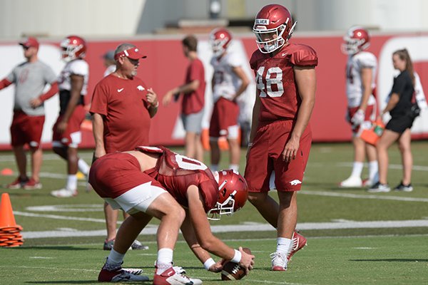 Arkansas' Trey Purifoy snaps Tuesday, Aug. 20, 2019, as long snapper Jordan Silver (48) watches during practice at the university's practice facility in Fayetteville. 