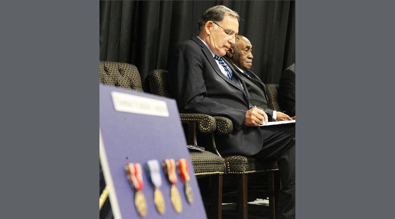 With his World War II medals in the foreground, 99-year-old World War II veteran Thomas Franklin Vaughns (right) sits with U.S. Sen. John Boozman, R-Ark., at the University of Arkansas at Pine Bluff on Wednesday. Video is available at arkansasonline.com/822medals. 