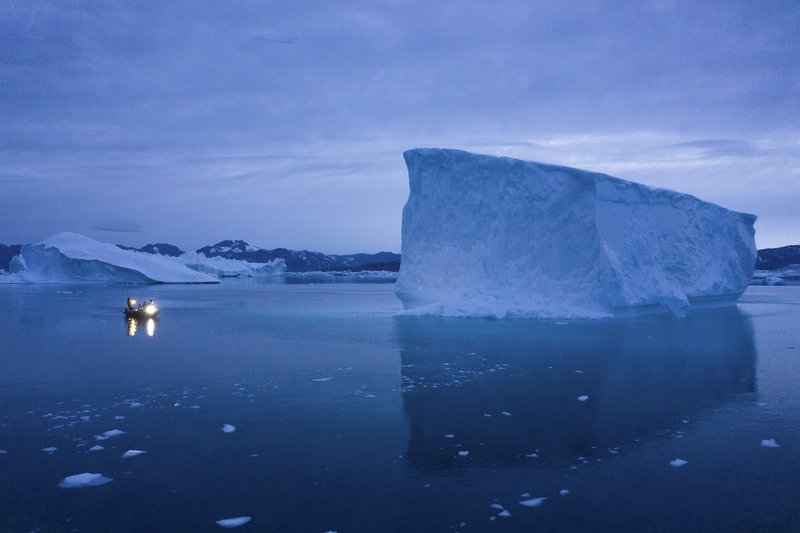In this Aug. 15, 2019, photo, a boat navigates at night next to icebergs in eastern Greenland. U.S. President Trump announced his decision to postpone a visit to Denmark by tweet on Tuesday Aug. 20, 2019, after Danish Prime Minister Mette Frederiksen dismissed the notion of selling Greenland to the U.S. as "an absurd discussion." (AP Photo/Felipe Dana)