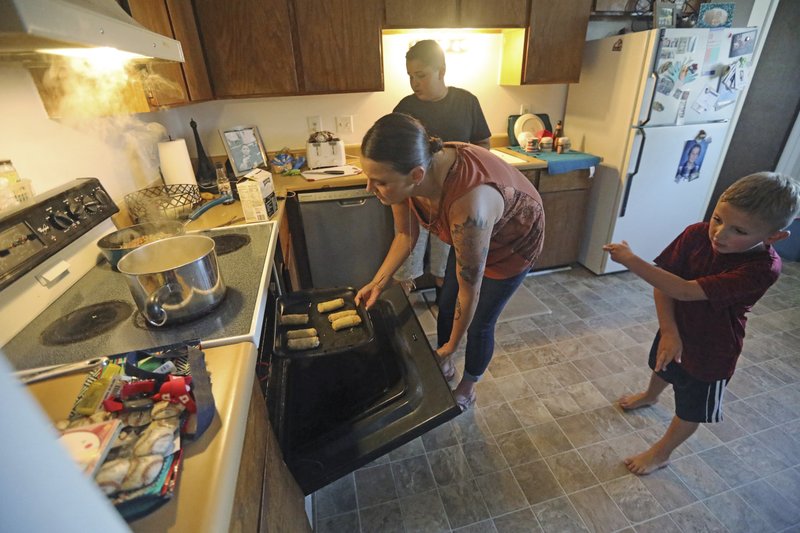 Misty Dotson prepares dinner for her son's at their home Tuesday, Aug. 20, 2019, in Murray, Utah. Dotson is a 33-year-old single mother of two boys, ages 12 and 6, who goes to Planned Parenthood for care through the Title X program. (AP Photo/Rick Bowmer)