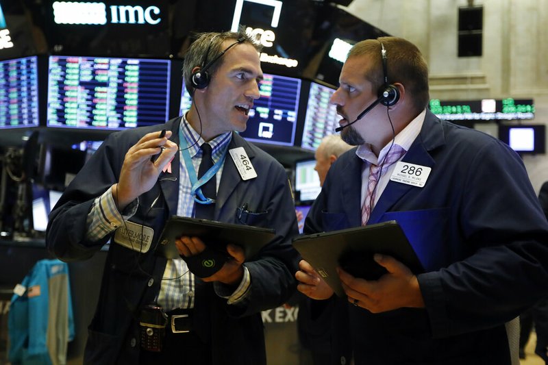 In this Aug. 19, 2019, file photo traders Gregory Rowe, left, and Michael Milano work on the floor of the New York Stock Exchange. The U.S. stock market opens at 9:30 a.m. EDT on Friday, Aug. 23. (AP Photo/Richard Drew, File)