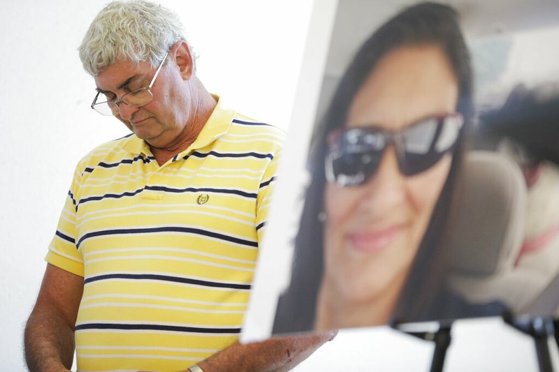FILE - In this July 25, 2019 file photo John Nicholas, brother of Rhogena Nicholas, lowers his head next to a photo of his sister during a news conference in Houston. A former Houston police officer has been charged with felony murder in connection with a deadly January drug raid that killed a couple and injured several officers, prosecutors announced Friday, Aug. 23. Killed in the shooting were 58-year-old Rhogena Nicholas and 59-year-old Dennis Tuttle.(Elizabeth Conley/Houston Chronicle via AP)