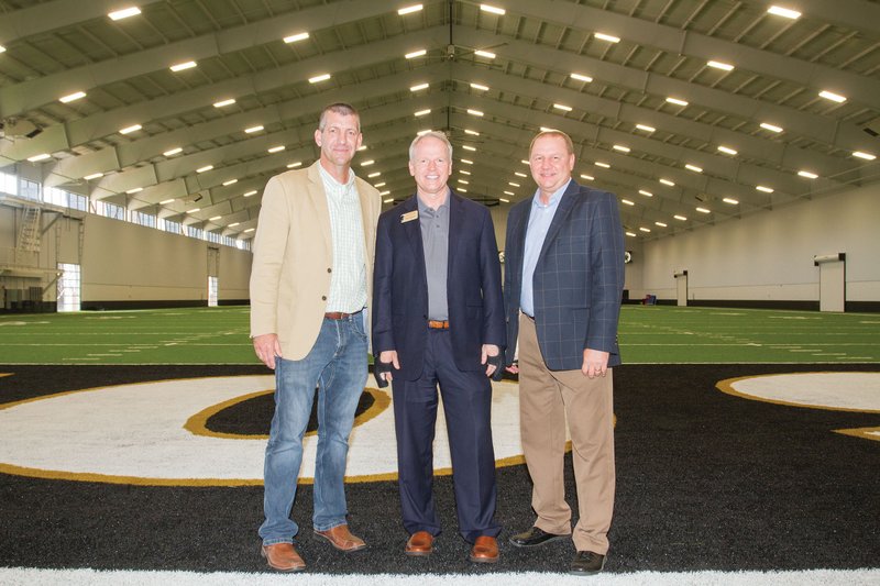 Harding University head football coach Paul Simmons, from left, Harding President Bruce McLarty and Athletic Director Jeff Morgan stand in the back of the end zone inside the new Huckeba Field House, which opened for the start of fall practice on the Harding campus in Searcy. The facility is named for former coach Ronnie Huckeba, who retired following the 2016 season.