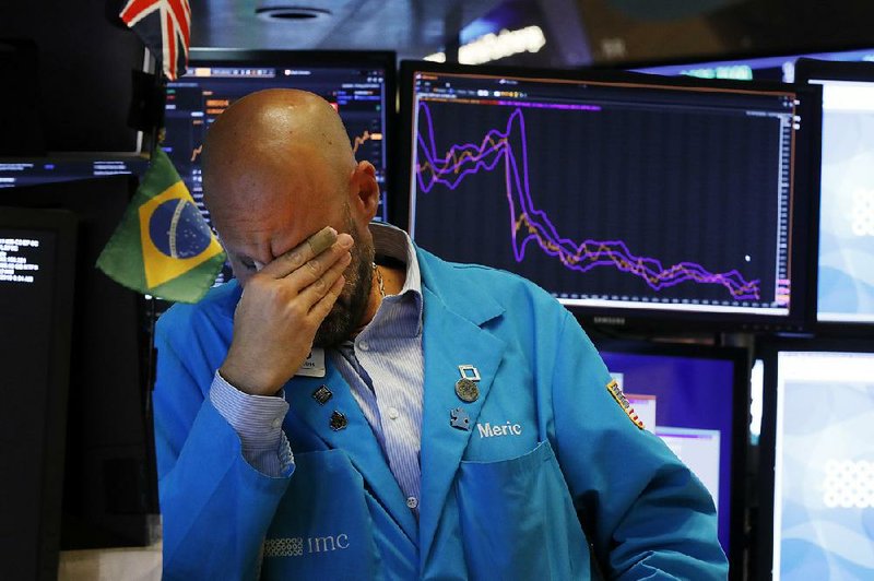 Specialist Meric Greenbaum takes a moment Friday on the floor of the New York Stock Exchange as stocks dived in a sweeping sell-off after China announced new tariffs on $75 billion in U.S. goods.