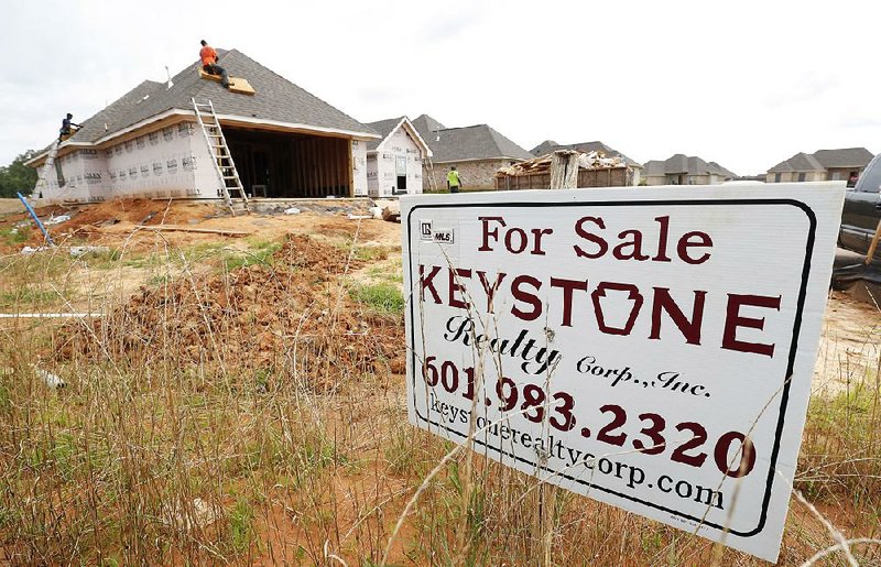 Workers install a roof in June on a new house in Brandon, Miss. New-home sales fell in July, missing 
estimates, after an upward revision for June took those sales to the highest level since 2007.