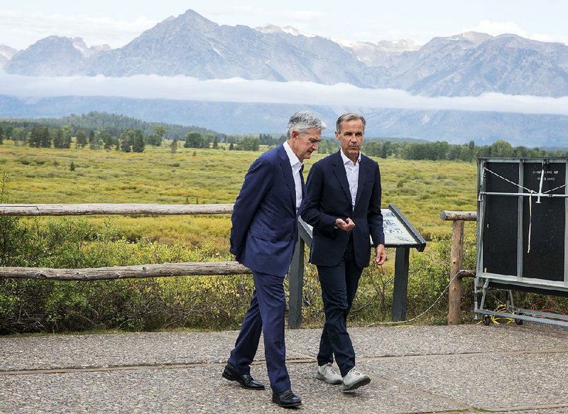 Federal Reserve Chairman Jerome Powell (left) and Mark Carney, governor of Great Britain’s central bank, walk together after Powell’s speech Friday at the annual gathering of global central bankers in Jackson Hole, Wyo.