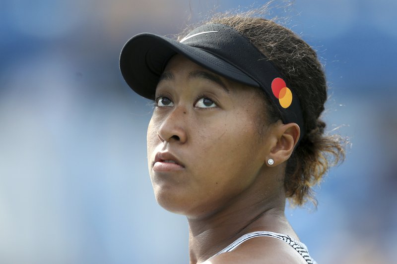 Naomi Osaka, of Japan, looks up a replay as she faces Sofia Kenin, of the United States, in the quarterfinals of the Western &amp; Southern Open tennis tournament Friday, Aug. 16, 2019, in Mason, Ohio. Osaka withdrew from the match with an injury. (Kareem Elgazzar/The Cincinnati Enquirer via AP)