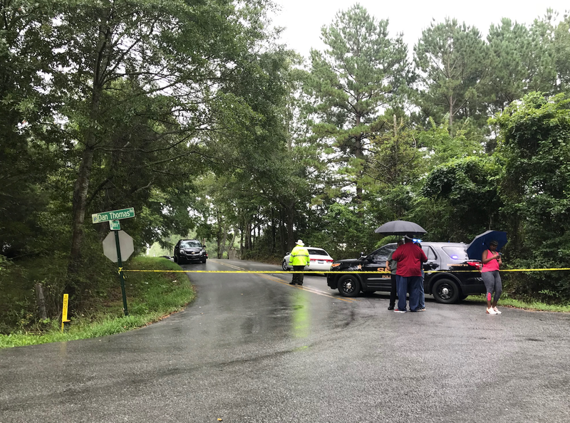 People gather at a roadblock near the scene of a homicide in Pulaski County on Saturday. 