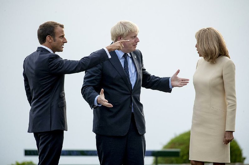 French President Emmanuel Macron (left) and first lady Brigitte Macron greet British Prime Minister Boris Johnson on Saturday at the summit in Biarritz, France. 