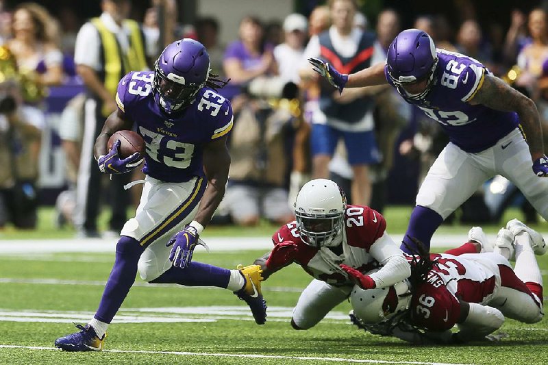 Minnesota Vikings running back Dalvin Cook (left) gets past Arizona Cardinals defenders Tramaine Brock (20) and D.J. Swearinger (36) during an 85-yard touchdown run in the first half of Saturday’s exhibition game in Minneapolis. Minnesota won 20-9. 