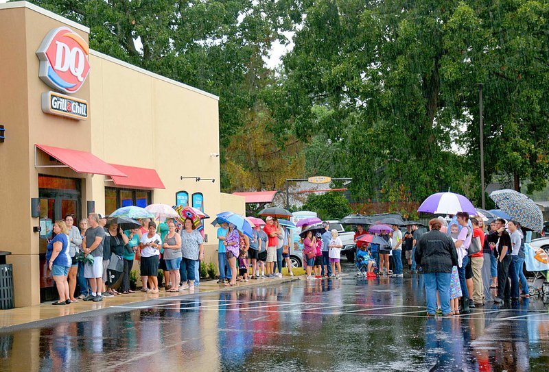 Janelle Jessen/Siloam Sunday Customers brave the rain to line up for the grand opening of the new Dairy Queen at the intersection of U.S. Highway 412 and Mount Olive Street on Thursday. The first 100 customers to purchase a Dairy Queen cake were offered free four-piece chicken strip baskets every week for a year. The DQ Grill &amp; Chill is the fourth location owned by Aimee and Terry Sims of Alabaster, Ala., and their second in Northwest Arkansas. In the future the couple plans to open a total of 10 locations in Northwest Arkansas. Several more restaurant chains are expected to open in Siloam Springs in coming months, including Popeyes, Freddy's and Starbucks.