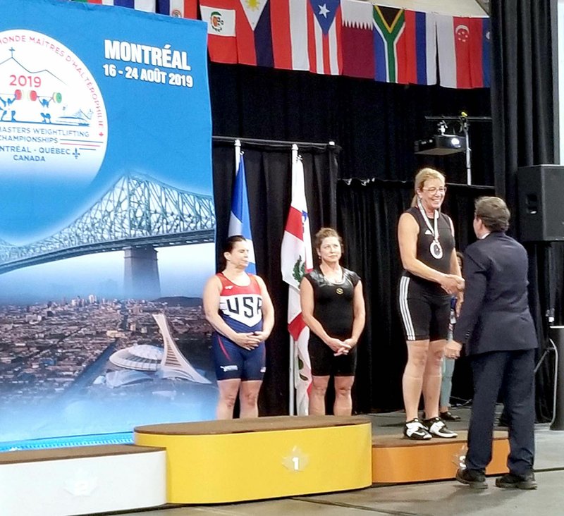 Janelle Jessen/Siloam Sunday Lynn Paskiewicz is presented with the bronze medal for Olympic-style weightlifting at the 2019 World Master's Weightlifting Championship in Montreal, Canada, last week. This is the second time she has won the award.