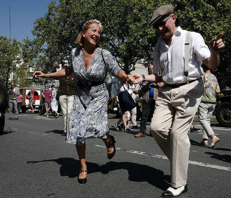 People dressed in World War II-era clothes dance Sunday in Paris during celebrations marking the 75th anniversary of the city’s liberation from Nazi occupation. A parade through Paris retraced the entry of French and U.S. tanks into the city on Aug. 25, 1944.
