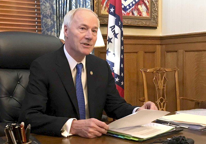 FILE - In this April 10, 2019 file photo, Arkansas Gov. Asa Hutchinson speaks to reporters in his office at the state Capitol in Little Rock, Ark. Hutchinson says the state should have harsher penalties for people convicted of targeting others because of their race, ethnicity or religion, calling for the measure in the wake of two mass shootings that include one in Texas being investigated as a hate crime by federal authorities. (AP Photo/Andrew DeMillo, File)