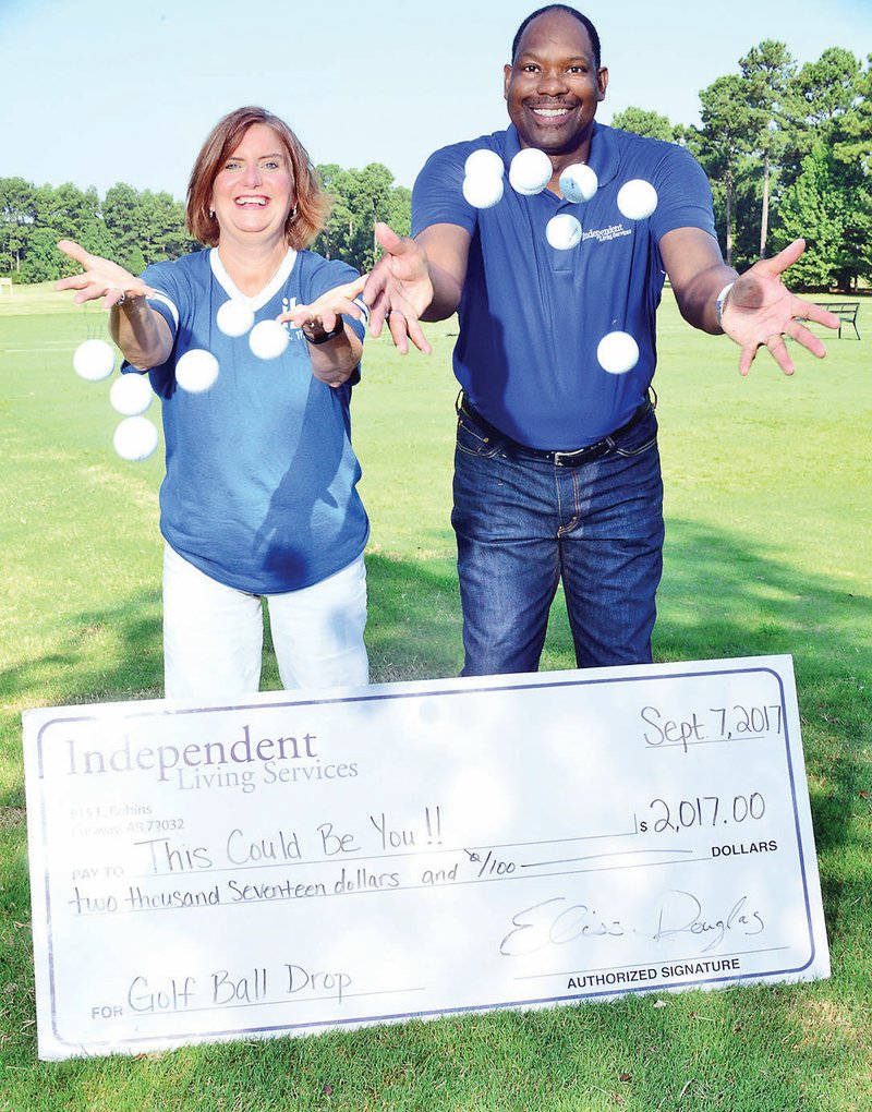 Elissa Douglas, executive director of Independent Living Services, and Robert Wright, director of development and supported employment for the nonprofit organization, throw golf balls into the air at Centennial Valley Golf and Country Club in Conway. The 14th annual Golf Ball Drop is set for 5:30-7 p.m. Sept. 5 at the club, 1600 Centennial Club Drive. 