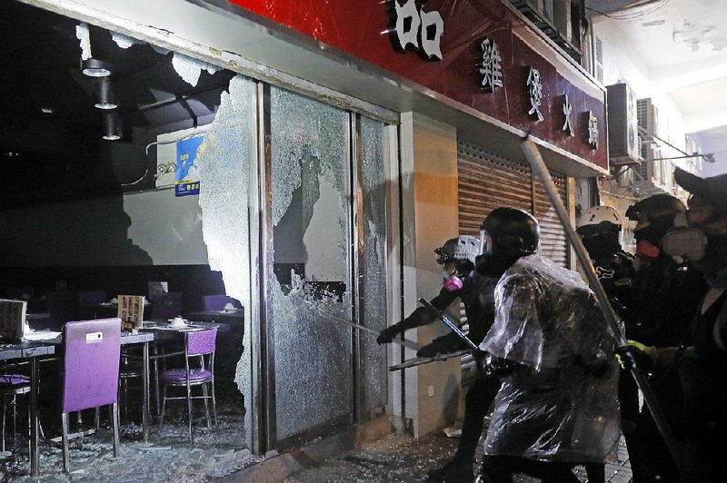 Demonstrators damage a steamboat restaurant run by a pro-China owner during a protest Sunday in Hong Kong. 