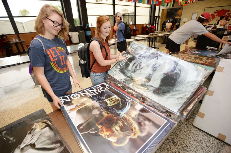 Friends Taylor Looper (left) and Abby Denison, both University of Arkansas students from Greenwood, sort through posters for sale Tuesday during the annual poster sale in the Arkansas Union on the university campus in Fayetteville. The sale which continues through Friday. NWA Democrat-Gazette/ANDY SHUPE