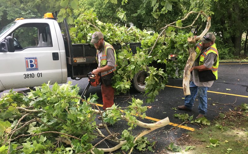Justin Merkey (left)  and Jimmy Green, both with the Bentonville Street Department, clean up fallen tree limbs Tuesday, Aug. 27, 2019 in Bentonville. 