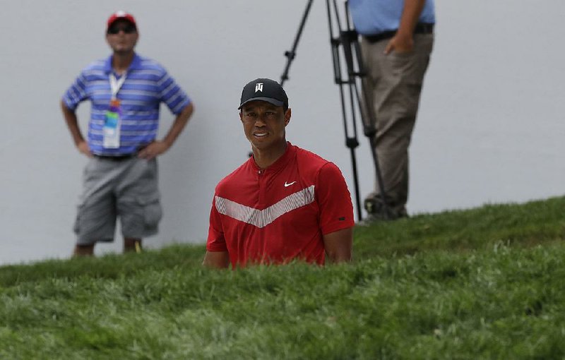 Tiger Woods watches as he hits from a bunker on the 13th hole during the final round of the BMW Championship golf tournament at Medinah Country Club, Sunday, Aug. 18, 2019, in Medinah, Ill.