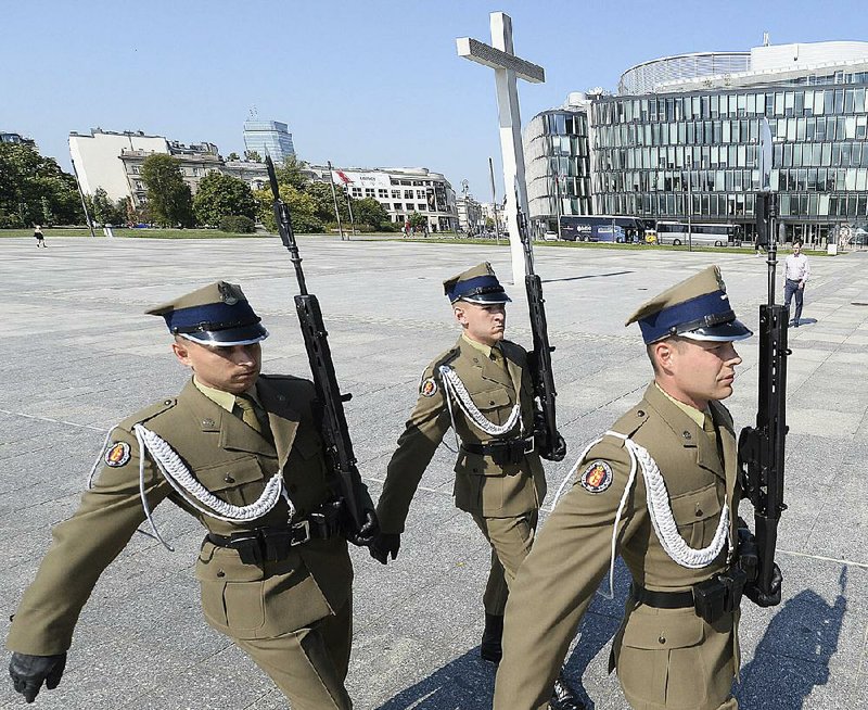 Polish soldiers conduct a changing of the guard Tuesday at Poland’s Tomb of the Unknown Soldier at Pilsudski Square in Warsaw. President Donald Trump is expected to visit the city Sunday to mark the anniversary of the start of World War II. 