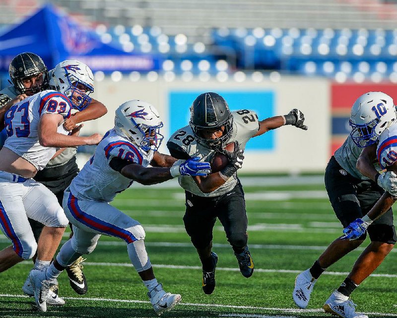 Little Rock Central running back Jeremiah Sample (28) runs past West Memphis linebacker Davion  Eason (16) during the Tigers’ 24-18 victory over the Blue Devils at War Memorial Stadium in Little  Rock on Tuesday. For more photos, visit arkansasonline.com/galleries. 