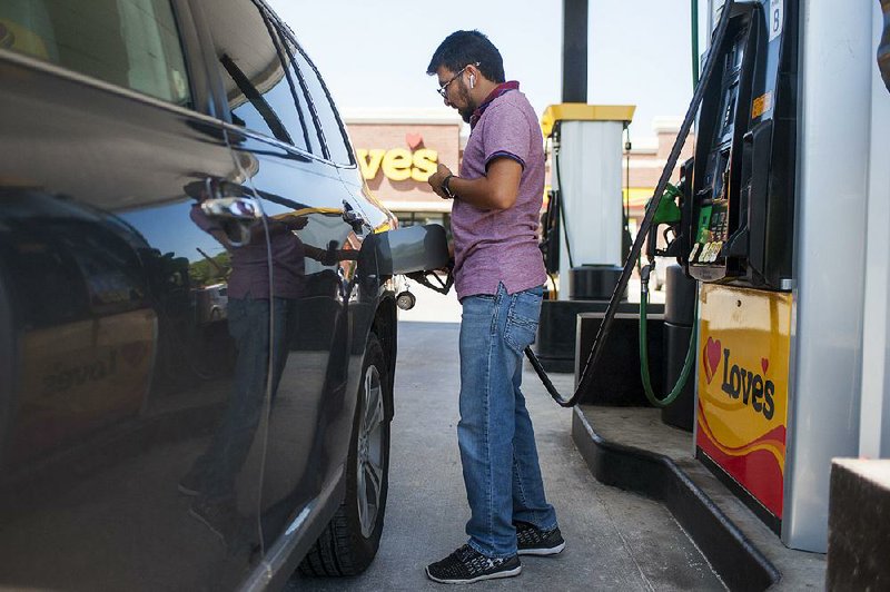 Ketan Patel of Kentucky fills up Wednesday at Love’s Travel Stop in Little Rock. Travelers will find low gas prices this weekend. In Arkansas, the average price for regular is 31 cents lower than a year ago. 