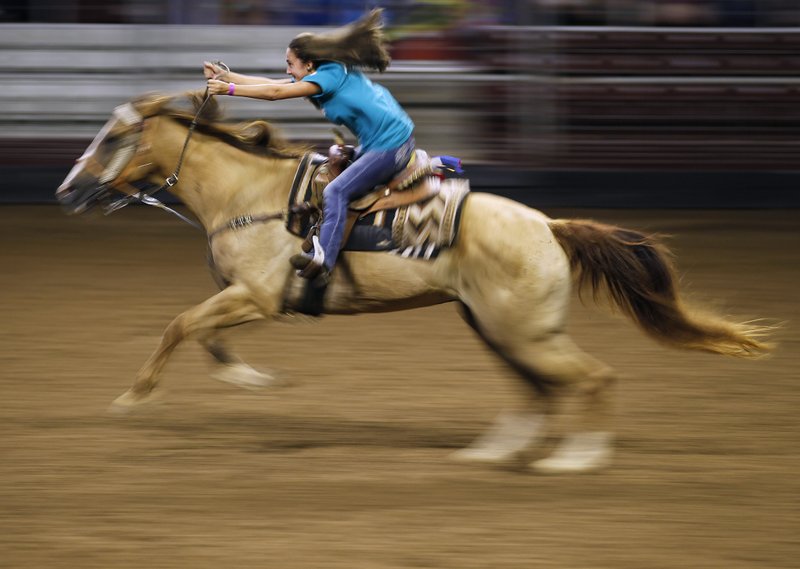 Harley Fleming races her horse across the arena in the Buckaroo Barrels Draw on Saturday, Sept. 1, 2018, during the Arkansas State Horse Show at the Arkansas State Fairgrounds in Little Rock. Arkansas Democrat-Gazette file photo/Thomas Metthe