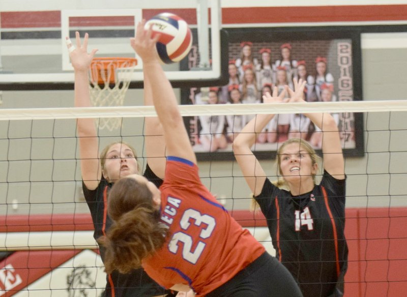 RICK PECK/SPECIAL TO MCDONALD COUNTY PRESS McDonald County's Sydnie Sanny (left) and Adyson Sanny go up to block a spike by Seneca's Haley Nash during the Lady Indians' 15-6, 15-10 in a scrimmage on Aug. 27 at MCHS.