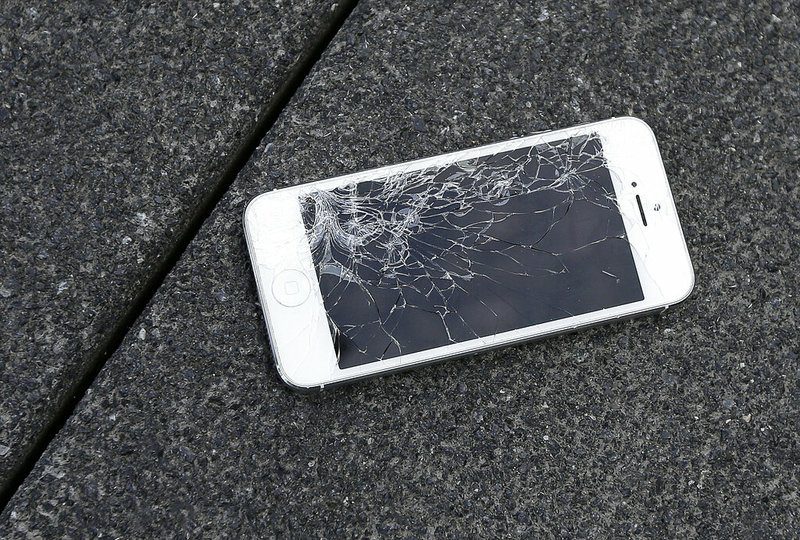 This Aug. 26, 2015 photo shows an Apple iPhone with a cracked screen after a drop test from the DropBot, a robot used to measure the sustainability of a phone to dropping, at the offices of SquareTrade in San Francisco. Apple said Thursday, Aug. 29, 2019, that it will sell tools and parts to independent phone-repair shops in the U.S. and later in other countries. The repair shops need to have an Apple-certified technician. Repairs at these shops, though, will be limited to products already out of warranty. (AP Photo/Ben Margot, File)