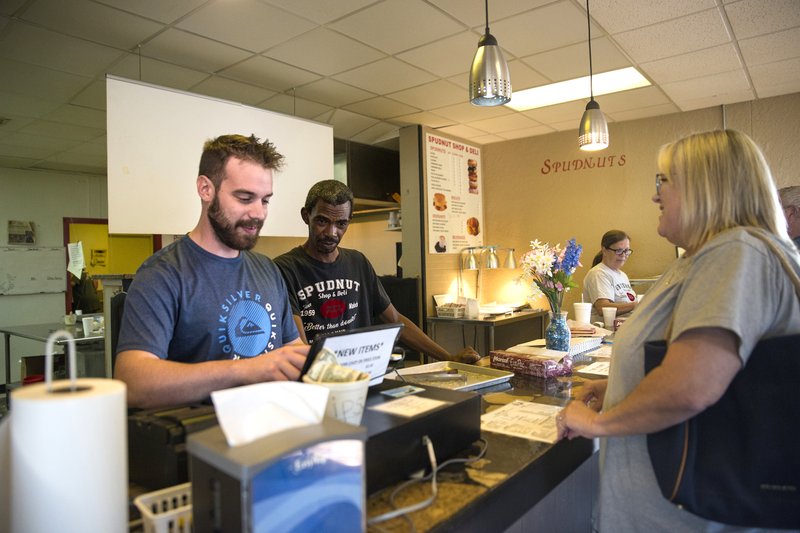 Spudnut Shop employees help customers order some of the last few potato-rich breakfast pastries on hand at the Magnolia restaurant on its final day of business on Thursday. The beloved local breakfast eatery first opened in Magnolia in 1959. 