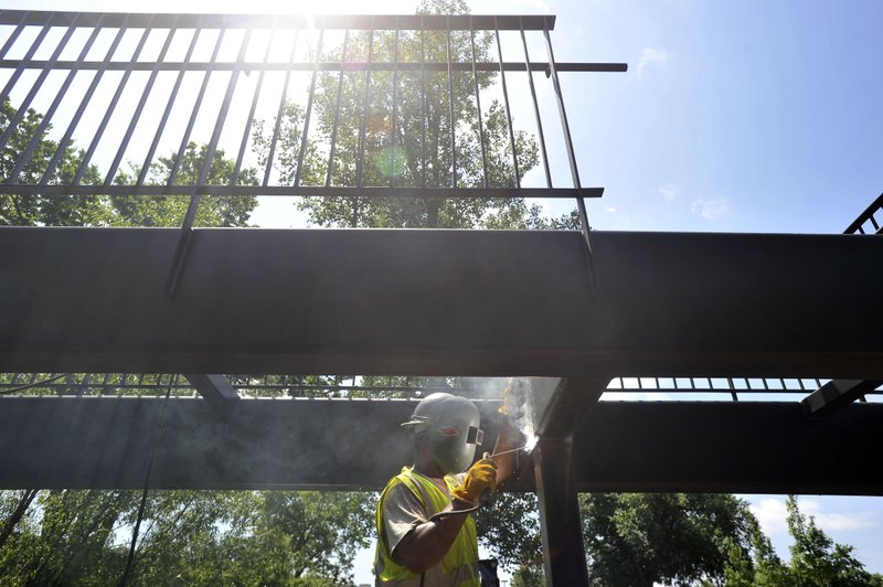 Jason Gober with NWA Steel located of Springdale, makes a weld on a new foot bridge at the Fayetteville Montessori School in 2015 as crews work on installing the new bridge.