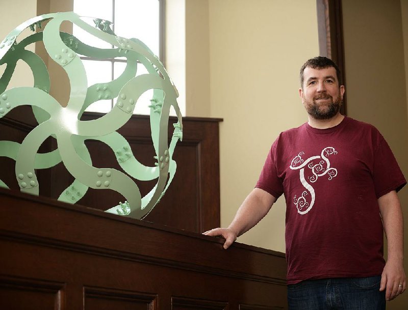 Edmund Harriss, an assistant math professor at the University of Arkansas, Fayetteville, shows off a mathematical shape he calls a “curvahedra” that’s similar to a 12-foot sculpture planned for the university’s Honors College. 