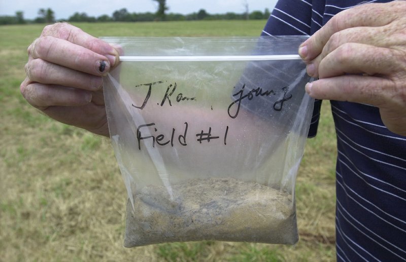 Collect slices or soil cores in a zig-zag pattern across your garden, mix in a bucket and put a pint of the soil mixture in a zipper-lock bag or a jar for soil testing. (Democrat-Gazette file photo)