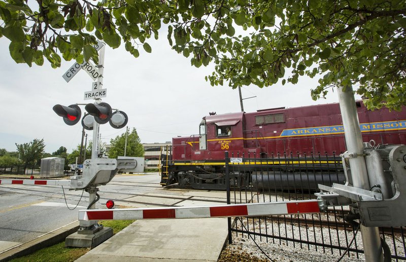 NWA Democrat-Gazette/BEN GOFF  @NWABENGOFF An Arkansas & Missouri Railroad train passes Aug. 22 at the crossing on East Emma Avenue in Springdale. The City Council on Tuesday night approved $486,860 to build a new crossing of the tracks at Maple Avenue -- and to pay for other conditions the railroad imposed.